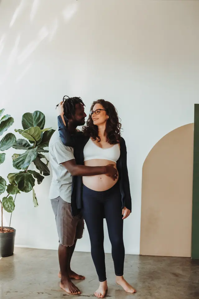 couple debout enlacé femme enceinte avec main de l'homme sur son ventre